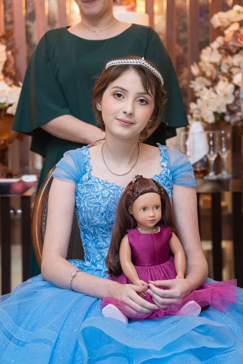 Debutante sentada com uma boneca no colo