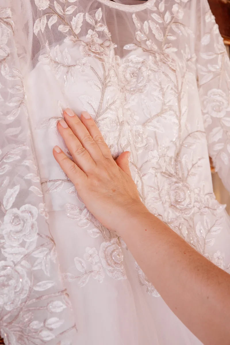 Mão tocando a renda do vestido