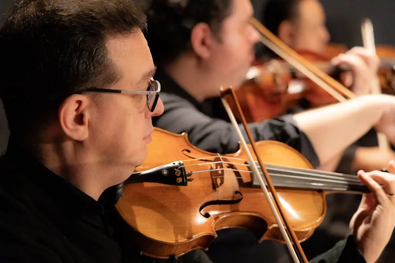 Violinistas em close durante a apresentação