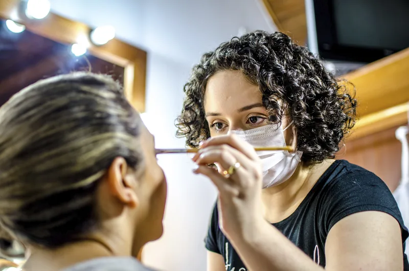 Nathalia aplicando maquiagem no olho da cliente