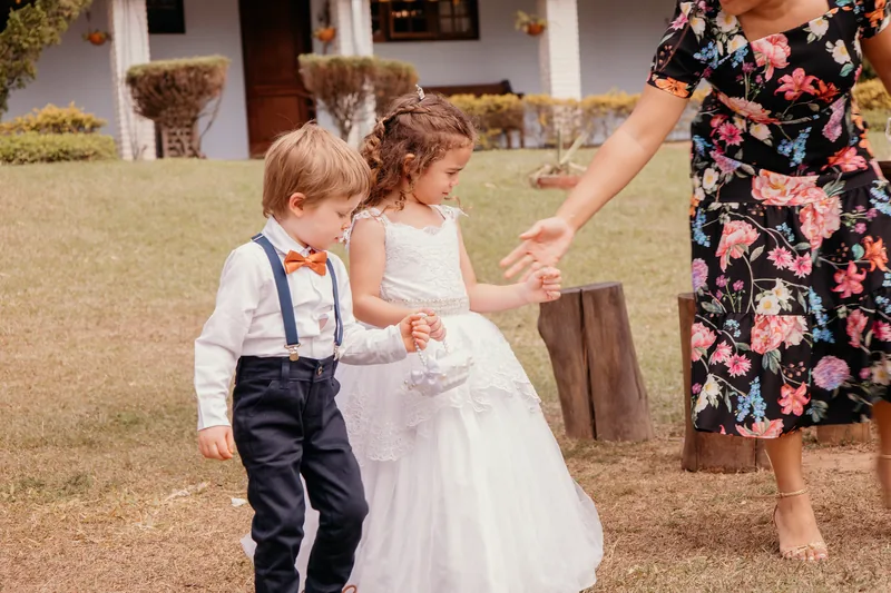 Pajem e daminha caminhando de mãos dadas