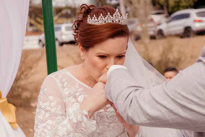 Noivo beijando a mão da noiva durante a cerimônia