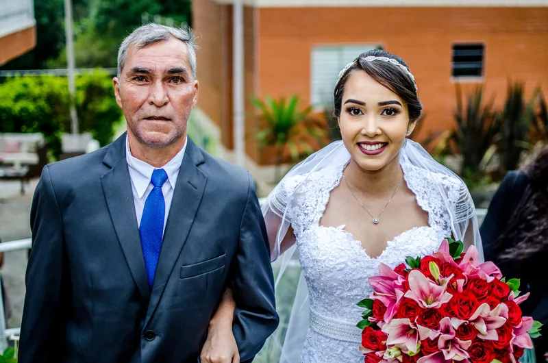 Noiva de braço dado com o pai, a caminho da cerimônia